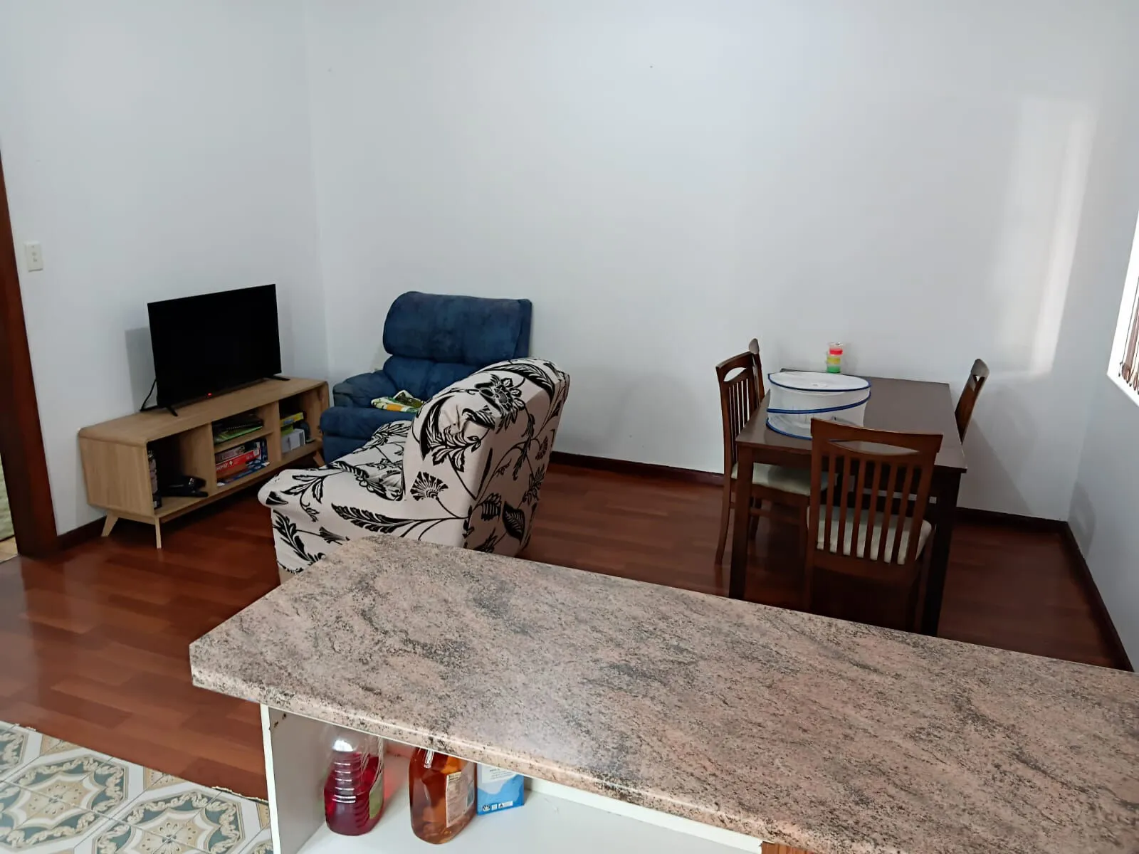 The living and dining area at Mascot House with a sofa, television and dining table.