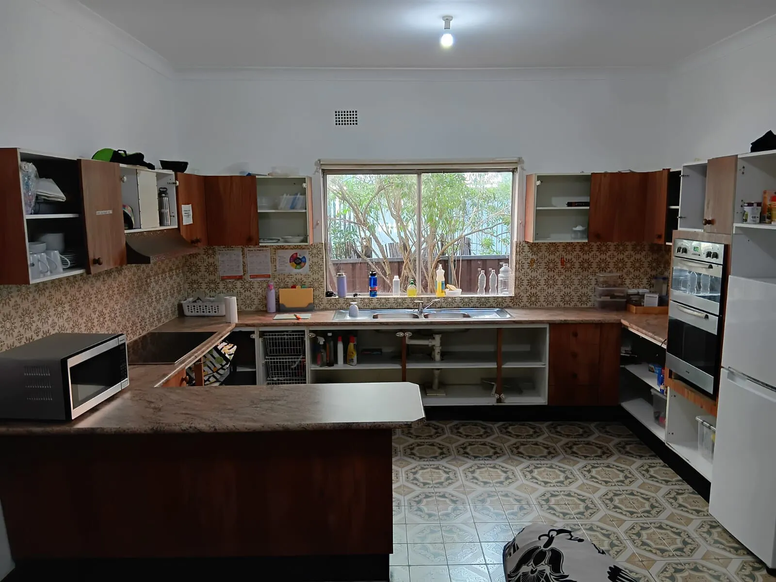 The kitchen at Mascot House with timber cabinets, a window over the sink and a breakfast bar.