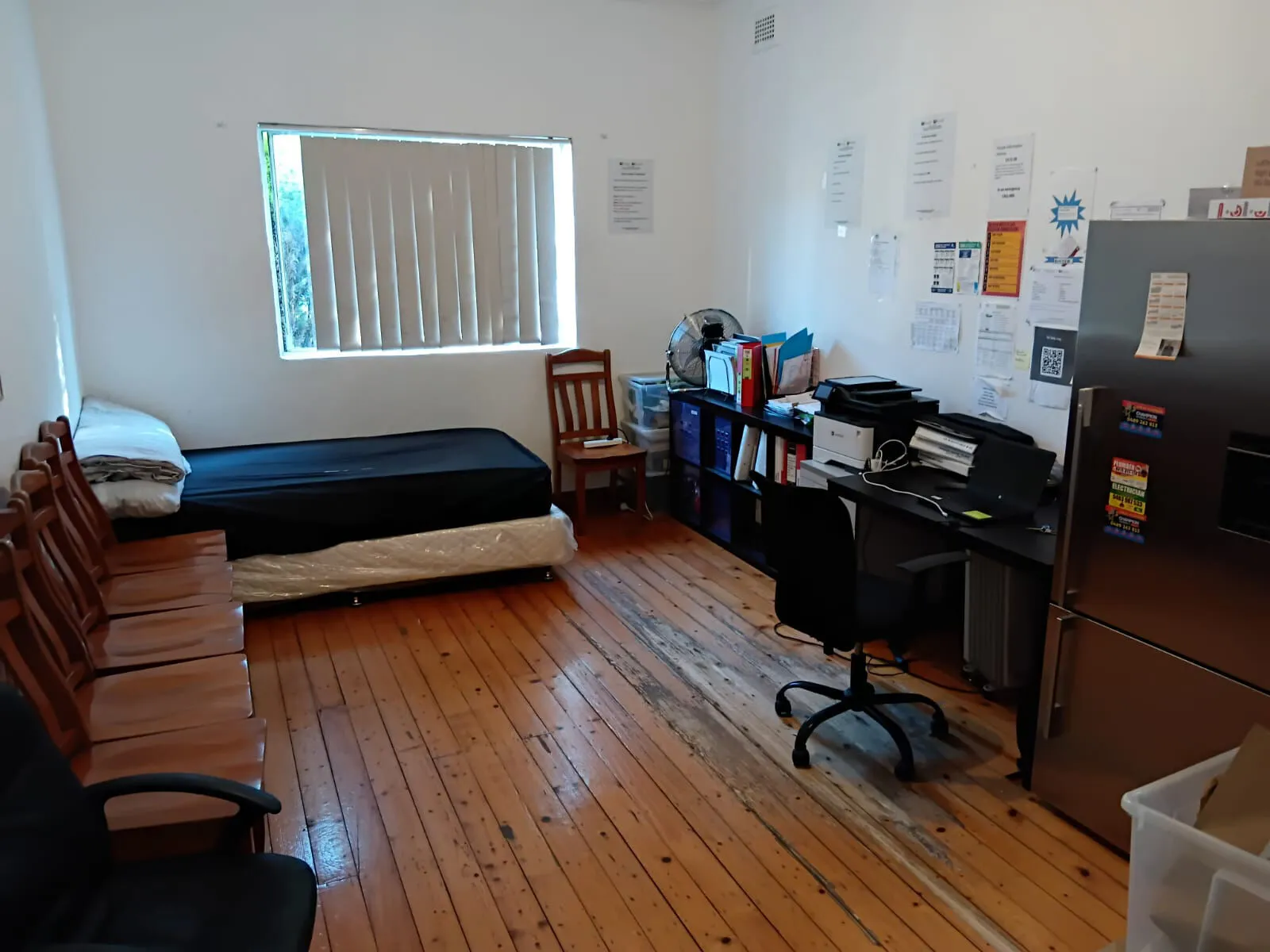A second bedroom at Mascot House with a bed, a desk and a fridge.