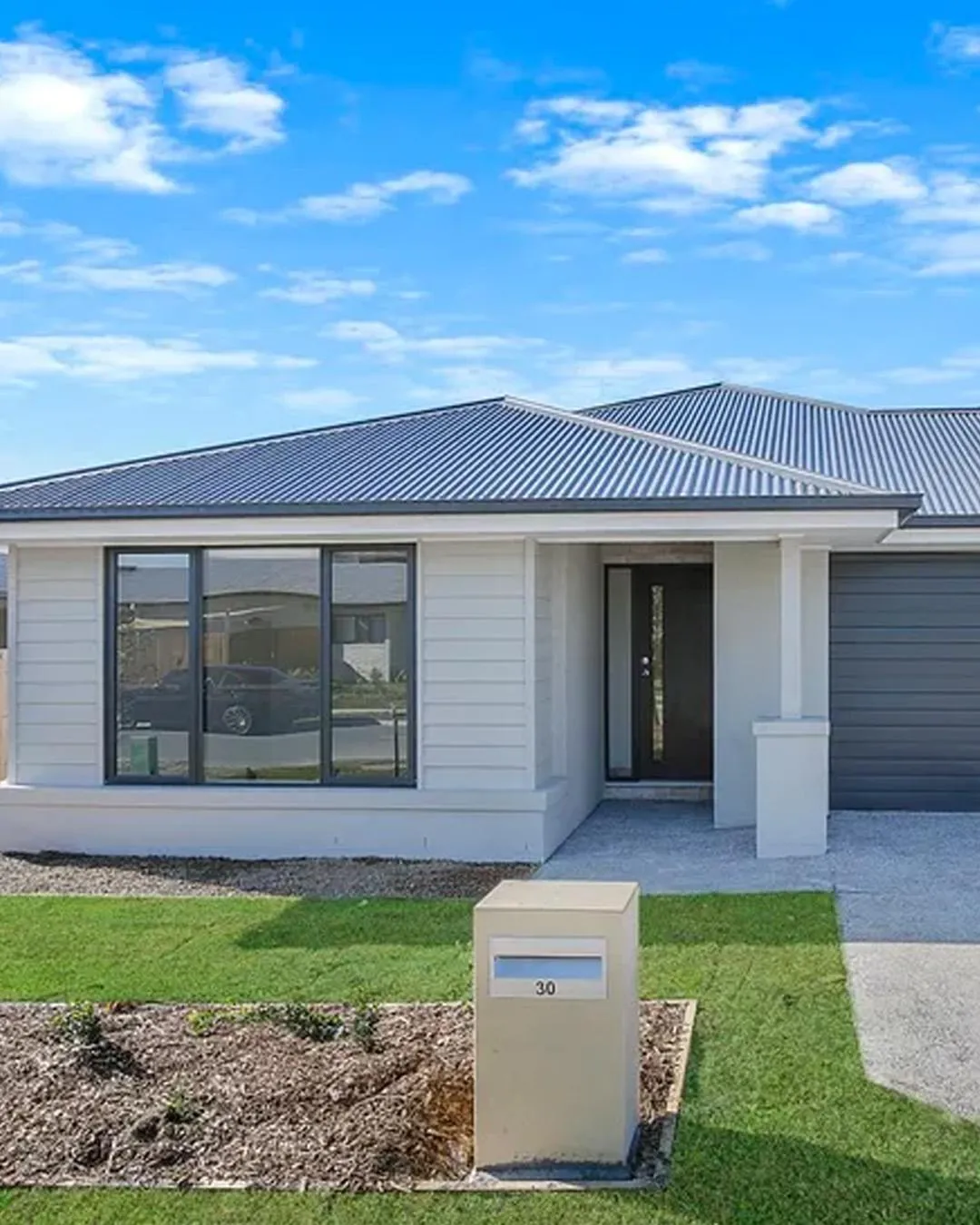 A brand-new single-level home in Park Ridge with light weatherboard cladding and a sheltered entry.