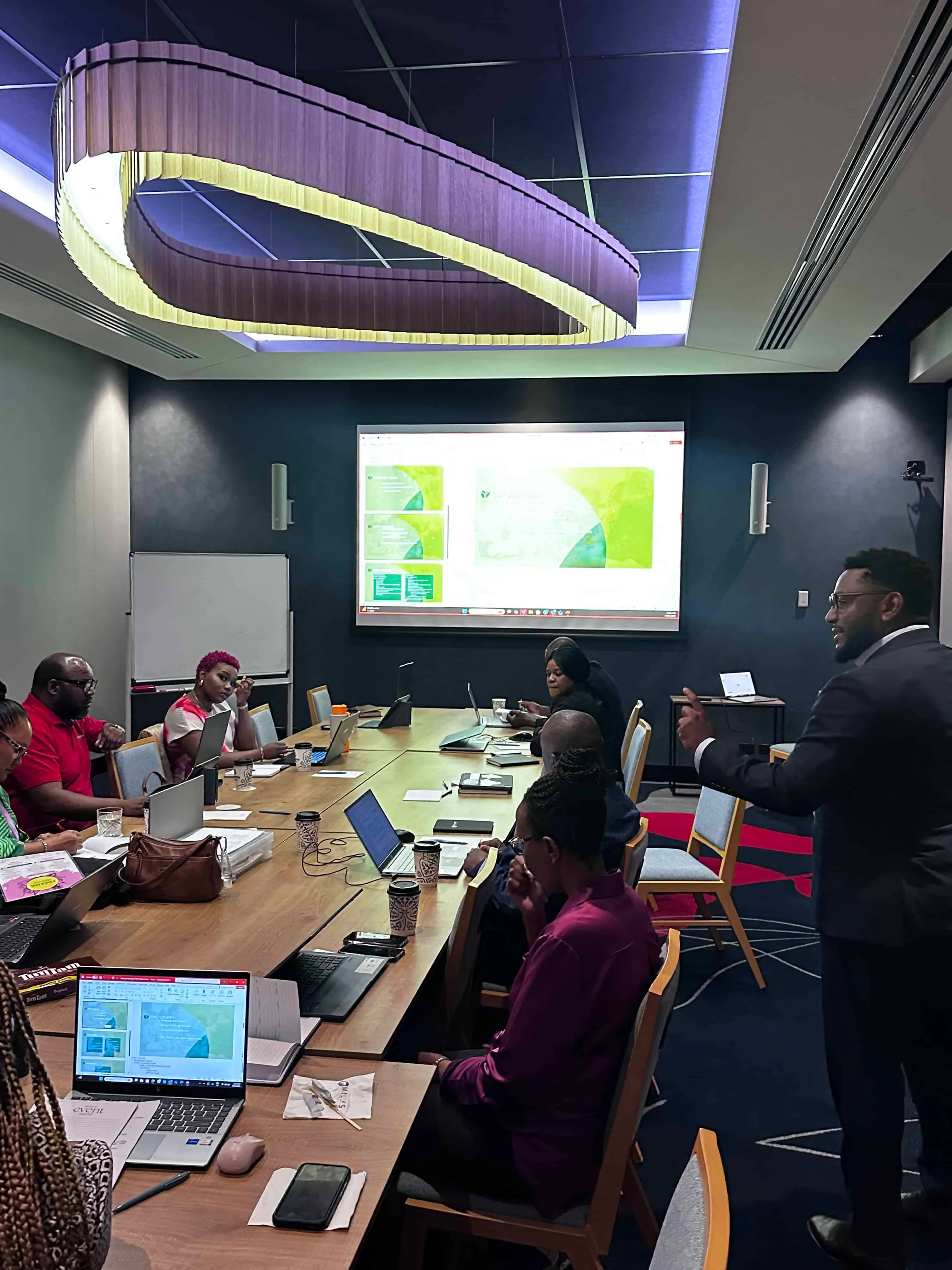 Phil Terry team members in a planning meeting, with a presentation on screen.